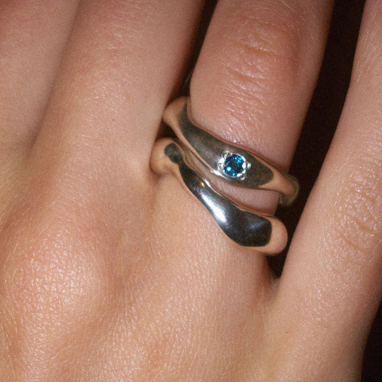 Motion ring with blue topaz paired with moton ring.