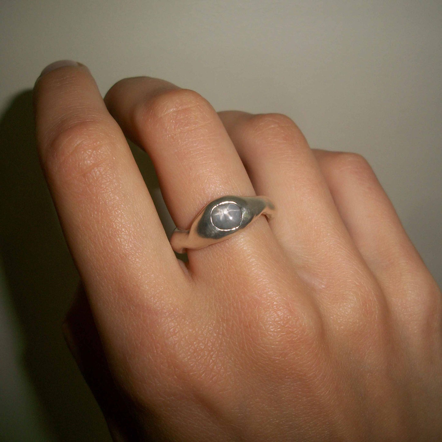 Unique Motion ring with grey star sapphire on hand