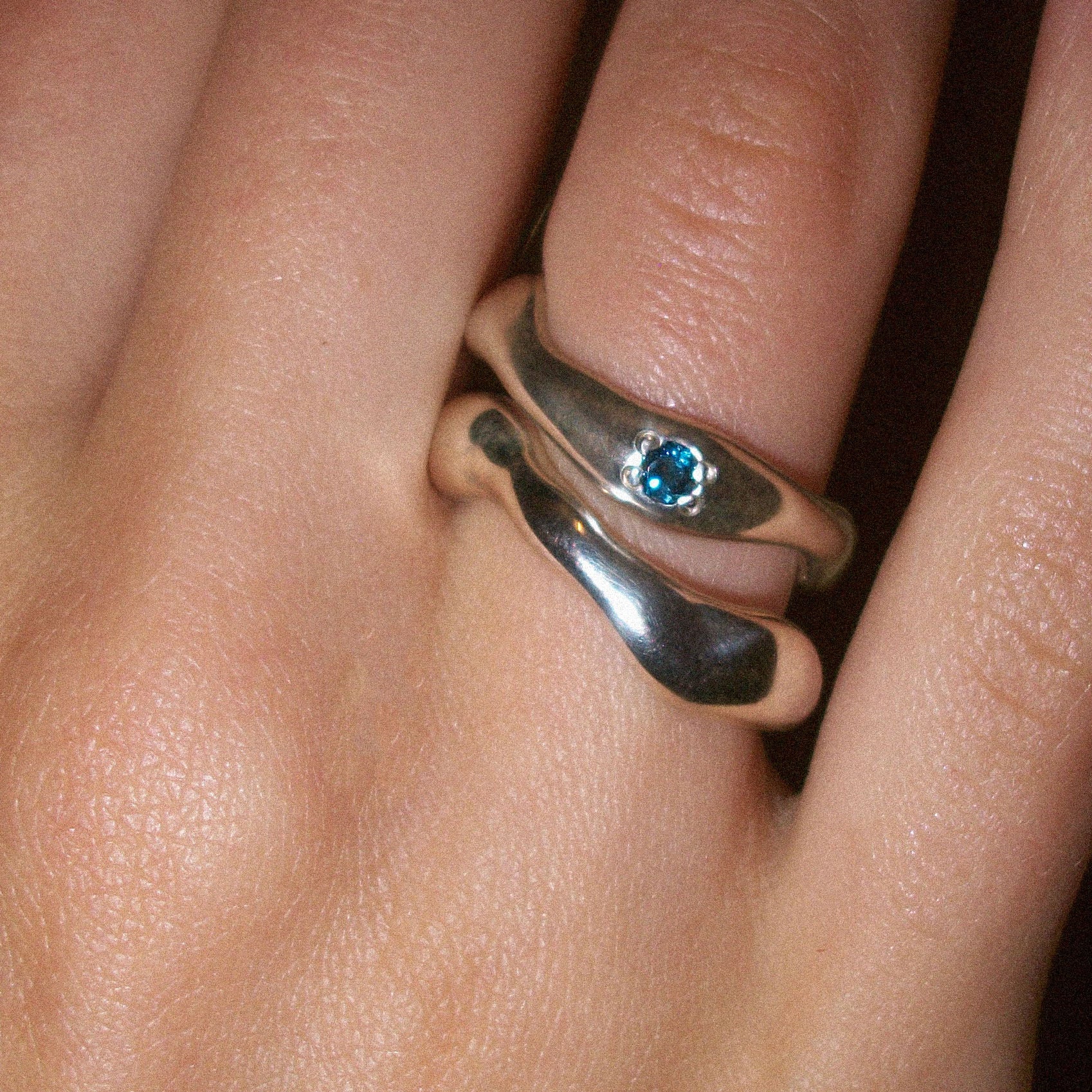 Motion ring with blue topaz paired with moton ring.