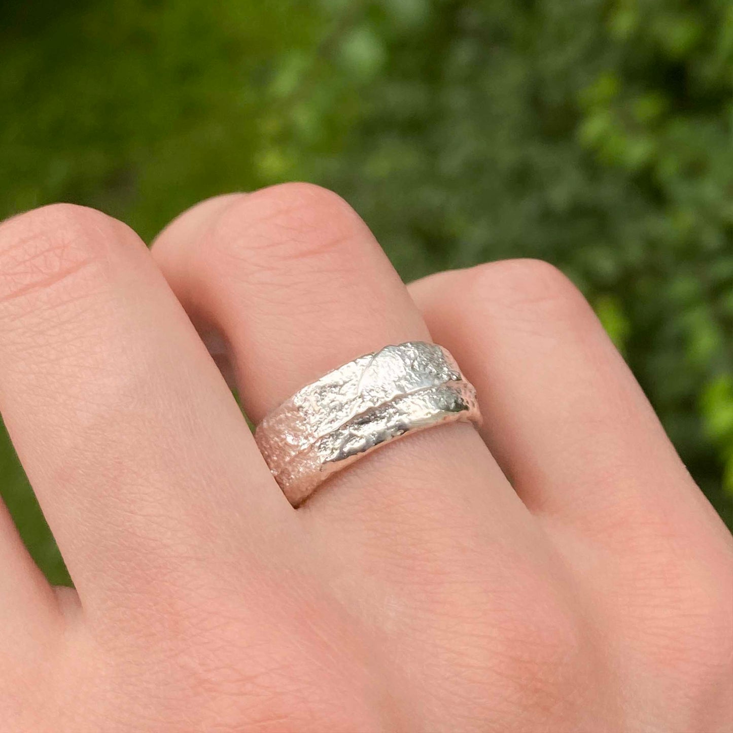 Sand Casted Silver ring on a finger 