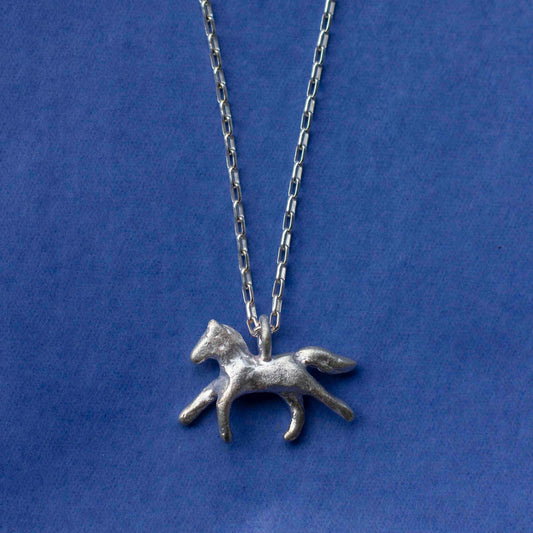 Silver horse pendant necklace on a blue background